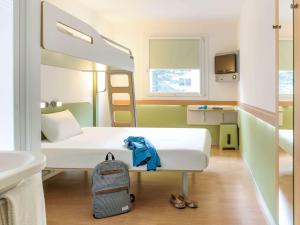 a hospital room with a bed and a backpack at ibis budget Bremen City Süd in Bremen