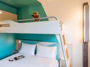 a bedroom with a bunk bed with a teddy bear on a ladder at ibis budget Koeln Porz in Cologne