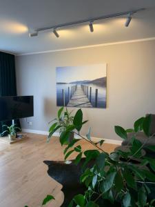 una sala de estar con una pintura de un muelle en Apartament Luna, en Biała Podlaska