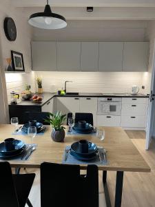 a kitchen with a wooden table with plates on it at Baltic Homes Lubiatowo in Lubiatowo