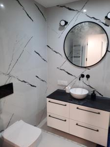 a bathroom with a sink and a mirror at Apartament Słoneczny Shellter Rogowo in Rogowo