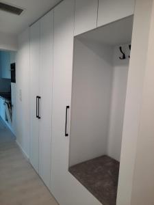 a room with white cabinets and a mirror at Apartament Słoneczny Shellter Rogowo in Rogowo