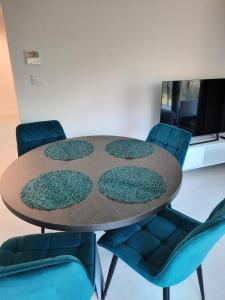a table with four chairs around it in a room at Apartament Słoneczny Shellter Rogowo in Rogowo