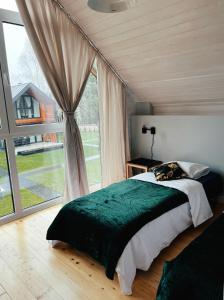 a bedroom with a bed and a large window at Baltic Homes Lubiatowo in Lubiatowo