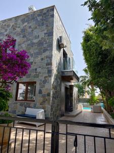 a stone house with a patio and a pool at Mosaic villa by the sea in Protaras