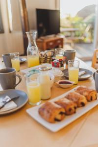 a table with a plate of food and glasses of orange juice at Pichilemu Domos in Pichilemu