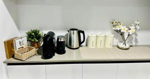 帕克漢姆的住宿－Spacious modern family home，一个带咖啡壶和鲜花的柜台