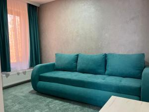 a blue couch in a living room with a window at Private house in Vaslui