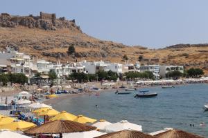 a beach with a bunch of umbrellas and buildings at Piazza Masari in Haraki