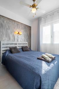 ein Schlafzimmer mit einem blauen Bett und Handtüchern darauf in der Unterkunft Inftour Primavera Apartamento in Calpe