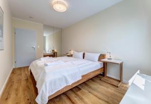 1 dormitorio con 1 cama grande y suelo de madera en Villa Madeleine App. 2 en Heringsdorf