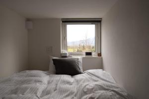 a white bedroom with a bed and a window at HOTEL BOTH in Shari