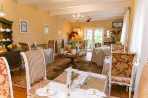 a dining room with white tables and chairs and a dining room at Maison Chablis Guest House in Franschhoek