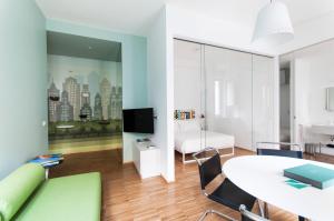 a living room with a white table and a green couch at Brera Apartments in Nerino in Milan