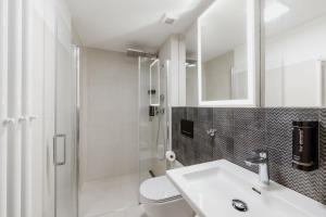 a bathroom with a toilet and a sink and a shower at Penzion Austis in Znojmo
