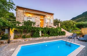 a house with a swimming pool in front of a house at Amalthia Cottage in Vathi, Ithaka