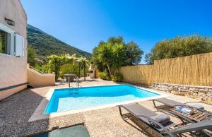a swimming pool in the backyard of a house at Arethusa Cottage in Vathi, Ithaka