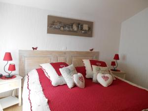 Un dormitorio con una cama con almohadas rojas y blancas. en Gite de la Streng, en Ribeauvillé