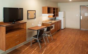 a kitchen with a television and a table with chairs at Extended Stay America Select Suites - Wichita - North in Wichita