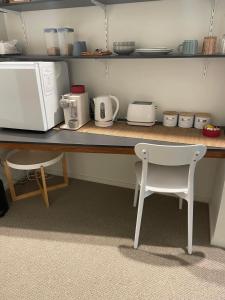 uma cozinha com um balcão com um micro-ondas e uma cadeira em Walk to Palmer B&B - U21 em Townsville