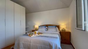 a bedroom with a bed with a tray of food on it at Blue by the Sea House in Paul do Mar