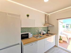 a small kitchen with a sink and a microwave at Lovely Terrace Apart. Downtown in Faro +11 photos