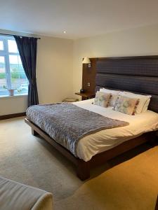 a bedroom with a large bed and a window at Tomahawk Steakhouse Potto in Potto