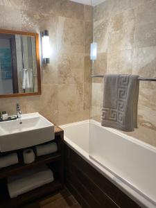 a bathroom with a sink and a bath tub at Fuego Steakhouse and Tapas -Tomahawk Potto in Potto