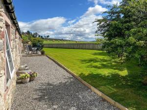 a garden with a yard with a grass field at Paterson Cottage in Tore