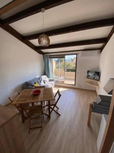 uma sala de estar com uma mesa e um sofá em Grand studio entre le golf et la plage à 800m em Saint-Cyprien-Plage