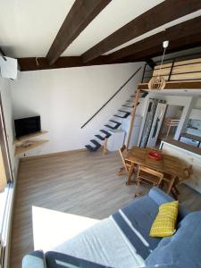 sala de estar con sofá azul y mesa en Grand studio entre le golf et la plage à 800m en Saint-Cyprien-Plage