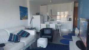 ein Wohnzimmer mit einer weißen Couch und einem Stuhl in der Unterkunft Apartamento La Ilusión - Cariño in Cariño