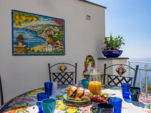 Blue Waves - De Vivo Realty Positano في بوسيتانو: طاولة مع وجبة إفطار من الكرواسون وعصير البرتقال