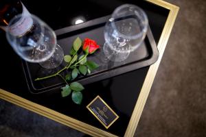 a table with wine glasses and a red rose on it at Hotel CITY Sandanski in Sandanski