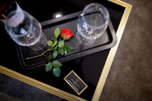 - une table avec des verres à vin et une rose rouge dans l'établissement Hotel CITY Sandanski, à Sandanski