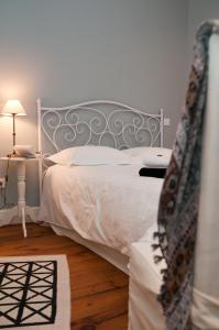 a bedroom with a white bed and a table with a lamp at Maison l'épicurienne in Les Sables-d'Olonne