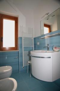 La salle de bains bleue est pourvue d'un lavabo et de toilettes. dans l'établissement B&B Virolì, à Vieste