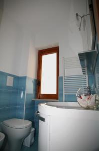 La salle de bains est pourvue d'une baignoire, de toilettes et d'un lavabo. dans l'établissement B&B Virolì, à Vieste