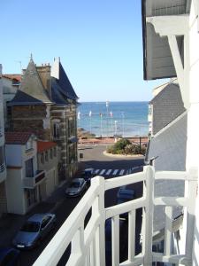 einen Balkon mit Blick auf eine Straße und das Meer in der Unterkunft Maison l'épicurienne in Les Sables-dʼOlonne