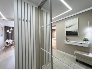 um corredor com uma porta de vidro deslizante que leva a uma sala de estar em Luxury apartments em Pavlodar