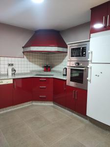 cocina con armarios rojos y fogones en CarreraHouses Campito, en Vigo