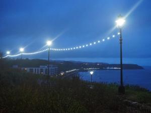 a row of lights on a hill next to a body of water at Hotel Ellenby in Scarborough