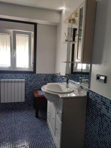 baño con lavabo y suelo de baldosa azul en CarreraHouses Campito, en Vigo