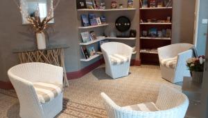 a room with four white chairs in a salon at Maison l'épicurienne in Les Sables-d'Olonne
