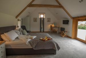 a bedroom with a bed with a tray of fruit on it at Goose Run Cottage in Corscombe