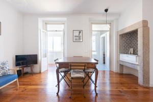 sala de estar con mesa de madera y TV en White & Blue Vintage Home in Graça en Lisboa