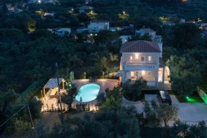 an aerial view of a house with a pool at night at Villa Melody Complex in Akrotiri