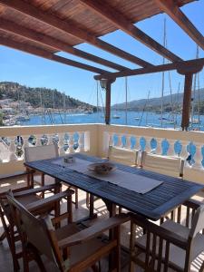 een tafel en stoelen op een balkon met uitzicht op het water bij Poros endless view apartment in Poros