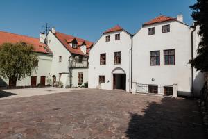 a group of white buildings with a driveway at Penzion Austis in Znojmo