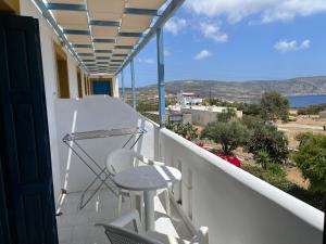 uma varanda com um banco e vista para o oceano em Angelos Furnished Apartments em Amoopi